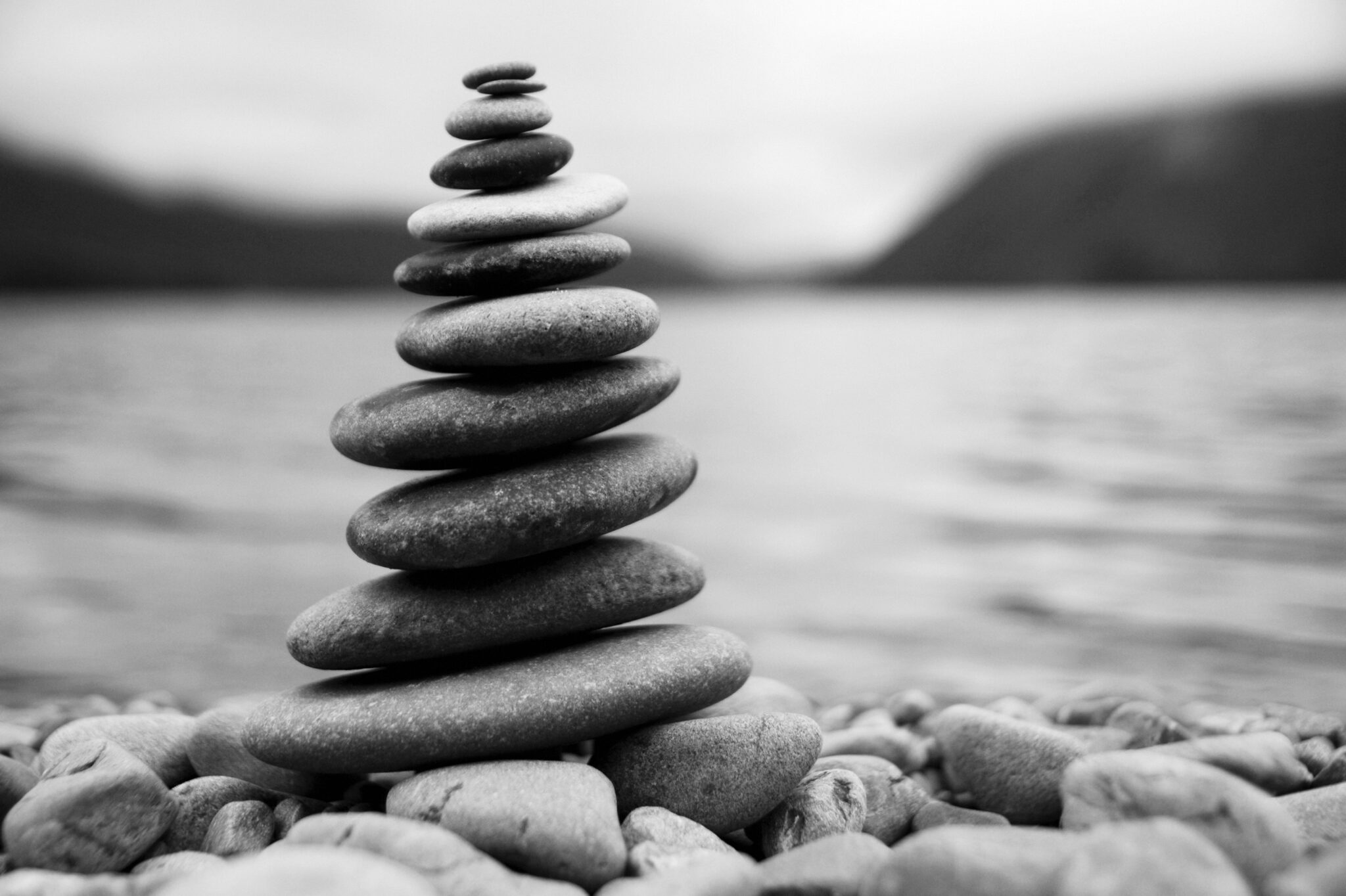 Balanced pebbles on a misty lake